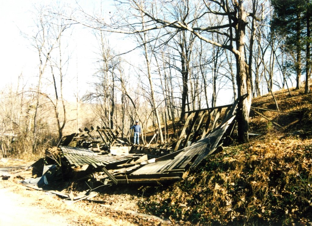 Salvaged lumber and roofing laid out on the ground during dismantling.
