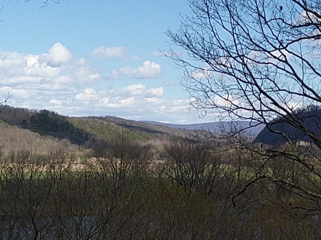 Spring view of the mountains and valley under a blue sky.